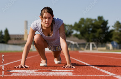 A pretty young woman exercising at a race track