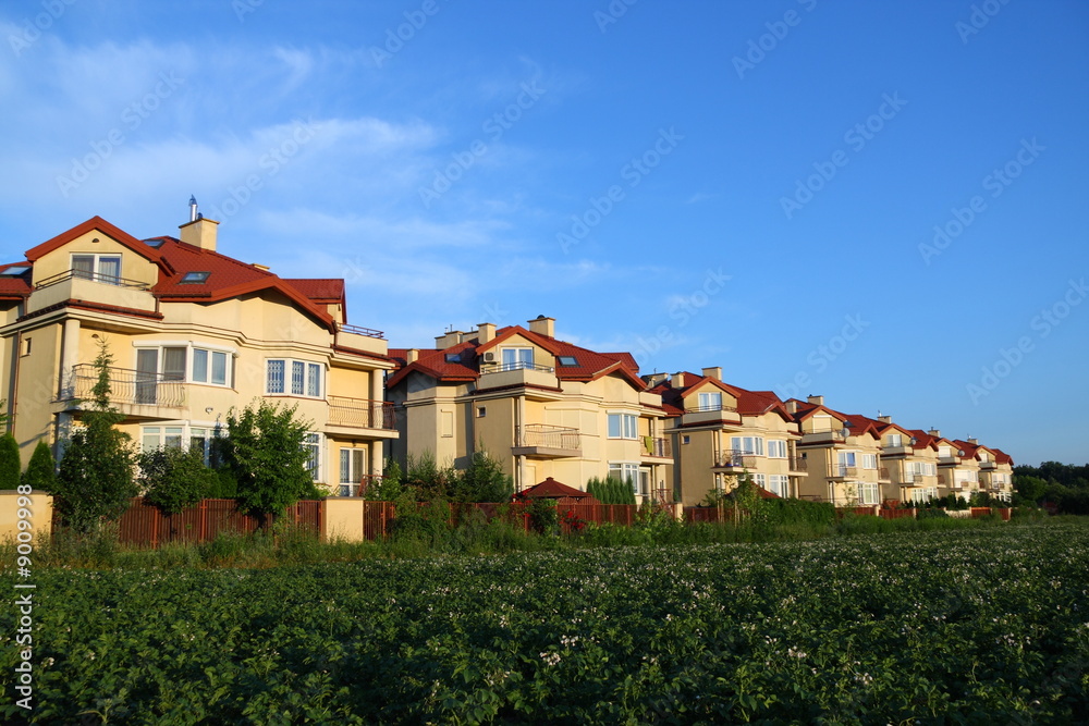 Row of similar houses over blue sky