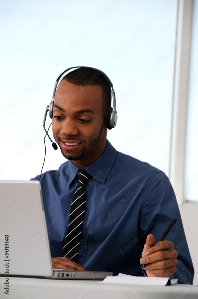 Customer Service agent in an office with laptop Customer Service agent in an office with laptop