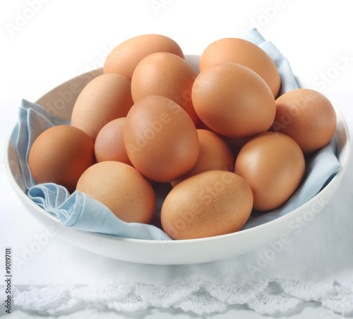 Bowl of brown eggs, with white and blue napery.