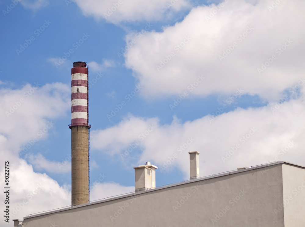 Big industrial chimney behind apartment building Big industrial chimney behind apartment building