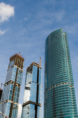 Builded skyscrapers on a background of the blue sky with clouds