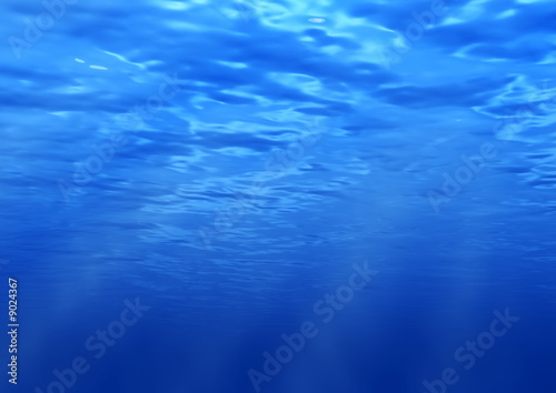 Beams of the sun underwater. Water background photo