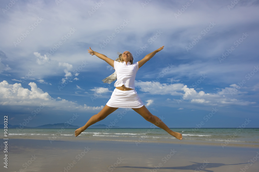Young woman jumping on the tropical beach