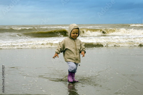 Enfant revenant de la mer avec ses bottes