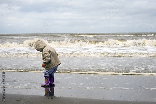 Enfant de profil à la mer, attendant les vagues