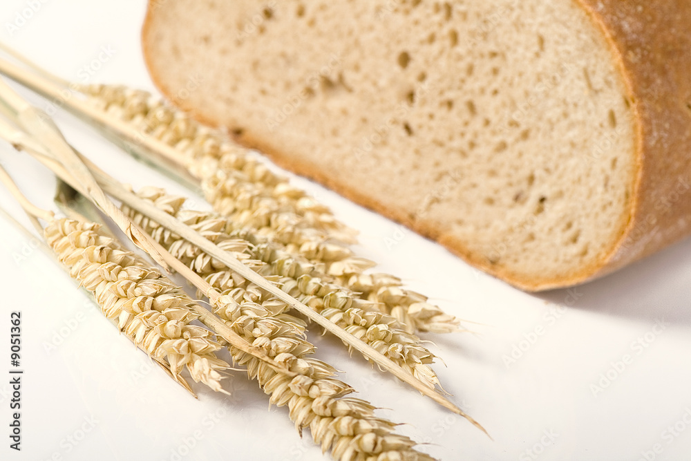 bread and wheat on white background