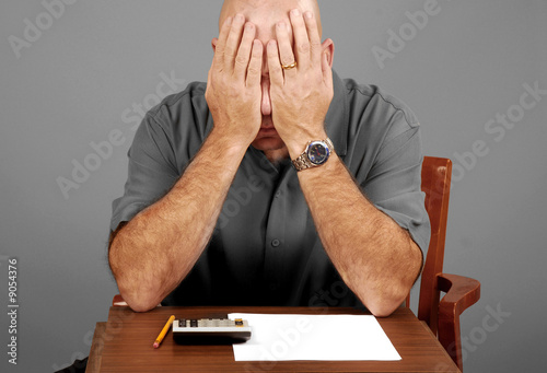 Man showing signs of stress while working budget