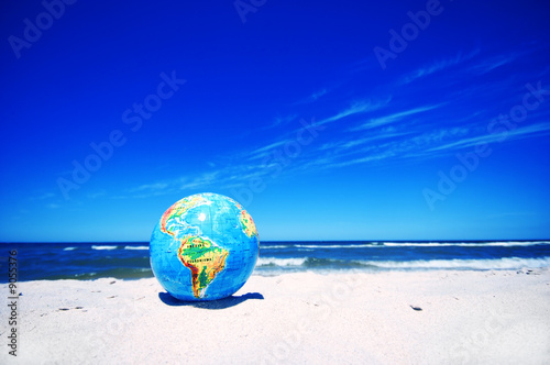 Earth globe on the beach. Ideal for Earth protection concepts photo