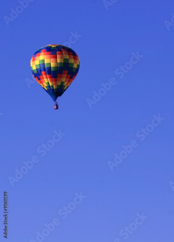 Colorful hot air balloon in blue sky with plenty of copy space © Whispers