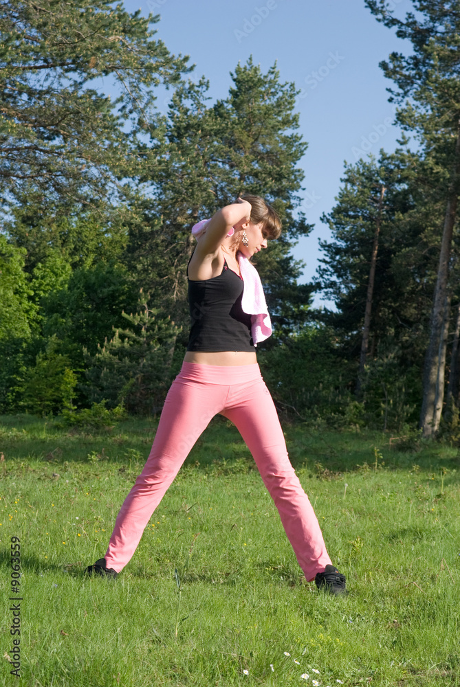 Young girl doing gymnastics in the nature with towel around neck Young girl doing gymnastics in the nature with towel around neck