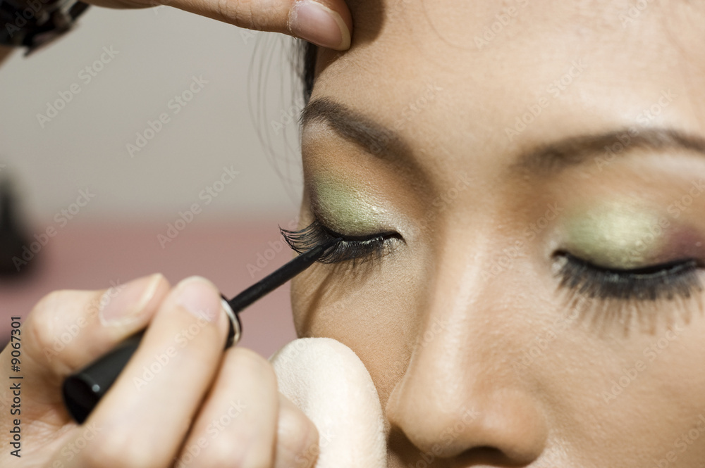A young woman applying makeup