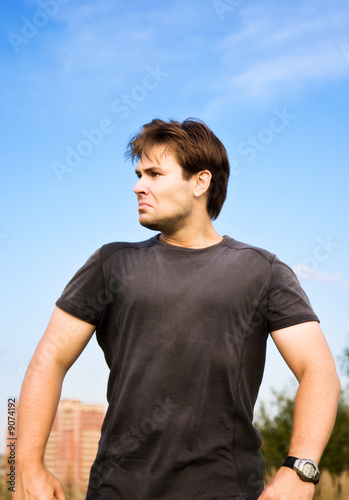 Very angry man walking. On blue sky background.