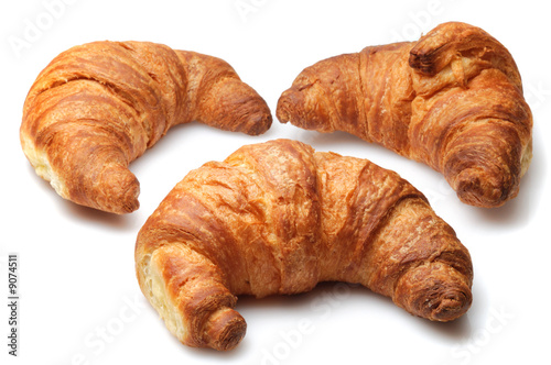 Three fresh croissants isolated over white background