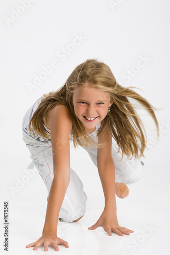 Teenage blonde girl standing on her knees and laughing