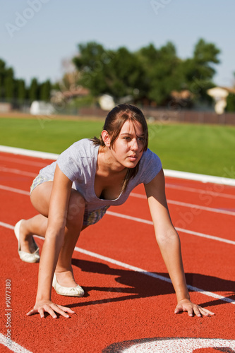 A pretty young woman exercising at the race track