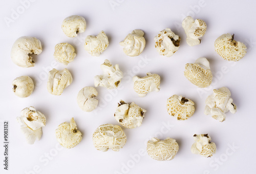 Popcorn grains spilted on white background