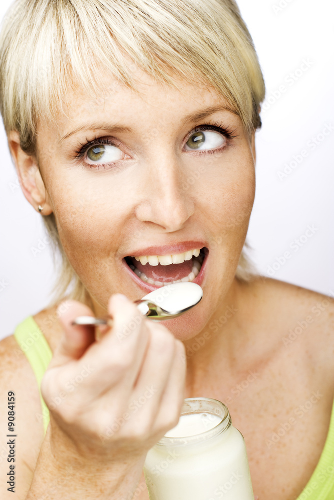 young beautiful woman eating yogurt close up young beautiful woman eating yogurt close up