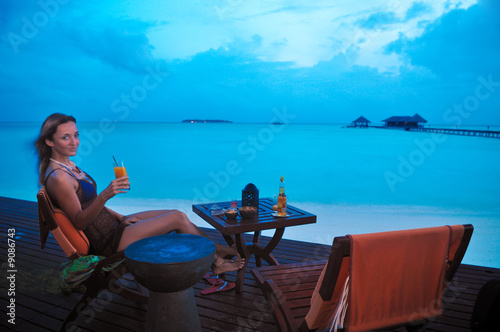 woman having a tropical cocktail at sunset