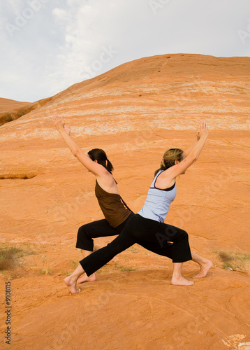 Women doing yoga poses in the desert