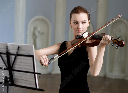 The beauty brunette plays the violin in concert hall