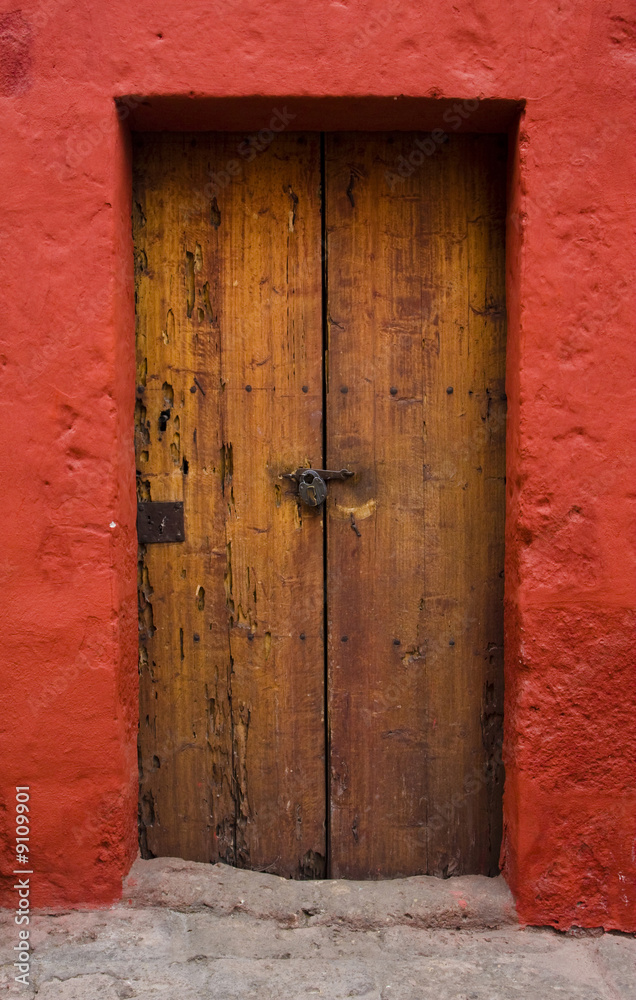 close up of ancient wood door and red wall