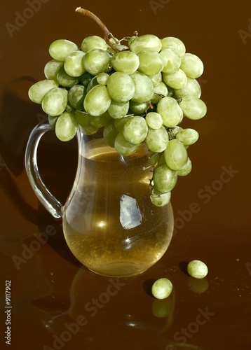 white grapes and wine in pitcher photo