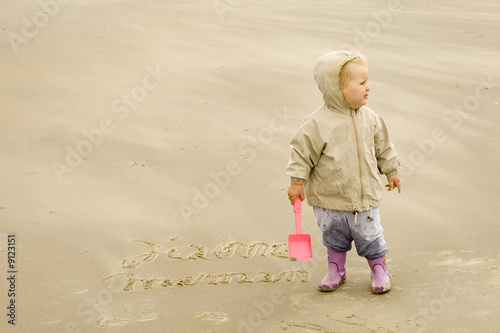 Fille écrivant j'aime maman sur le sable de profile