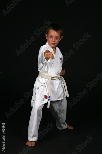 Young boy in glasses practicing traditional karate