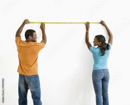 Couple measuring wall.