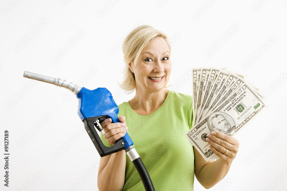 Happy woman with gas pump and money. Stock Photo | Adobe Stock