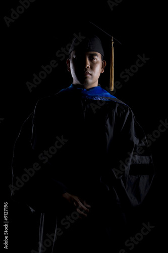 Bilde på lerret Low key image of a male model in graduation robes and regalia