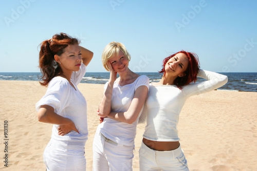 three cute girls relaxing on the beach