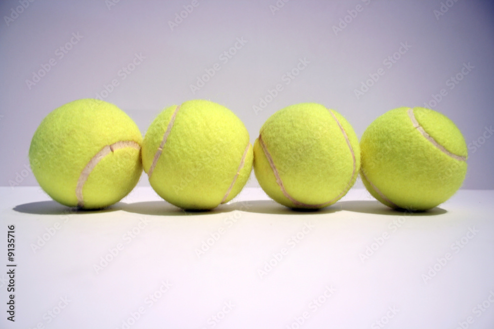 four tennis balls in line