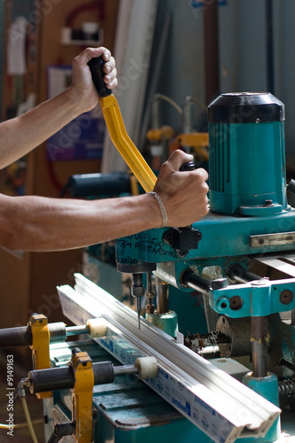 Hands using drilling machine to make holes