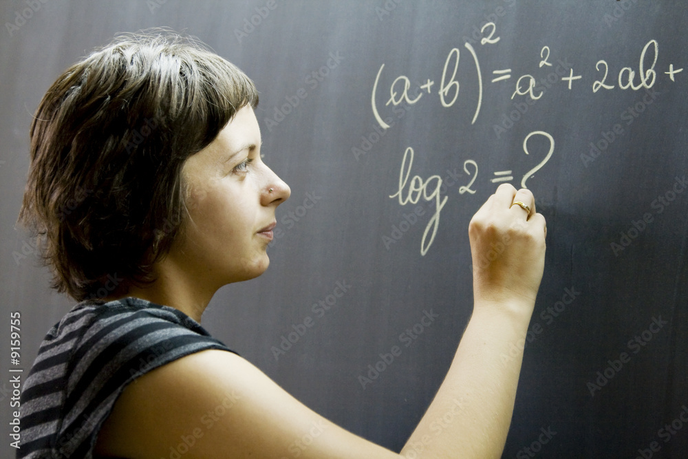 Teacher writing math formulas on blackboard