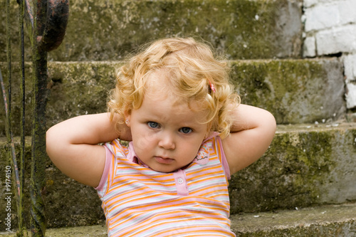 Enfant main derière la nuque et reculé sur un escalier