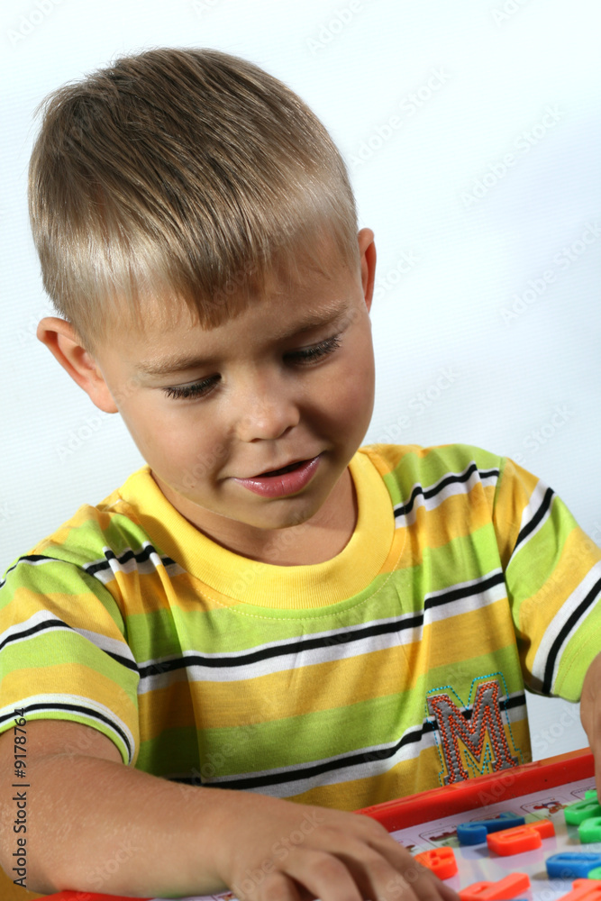 portrait of young boy with magnet letters portrait of young boy with magnet letters