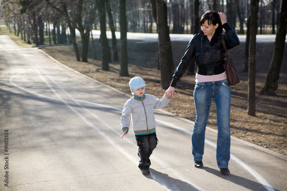 Fototapeta premium Mother and her son walking in a park