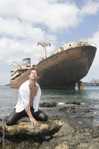 man in the seaside with abandoned trasatlantic under the sky photo