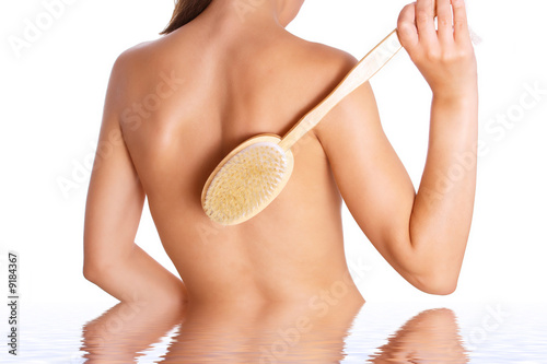 Photo of the woman with brush on back and reflexion in water