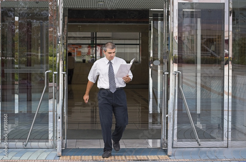 Businessman getting out of a corporate buidling