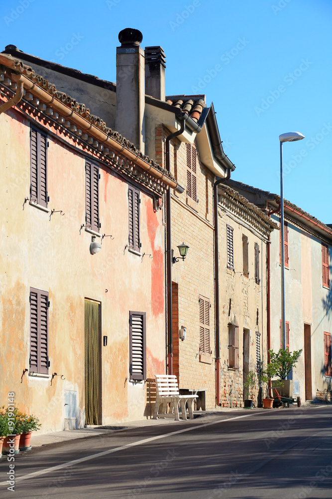 rural Italy - old houses lining a street in early sun