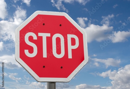 Stop sign against blue sky and clouds photo