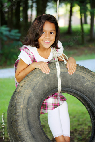 Girl Outside In Her Yard On A Tire Swing photo