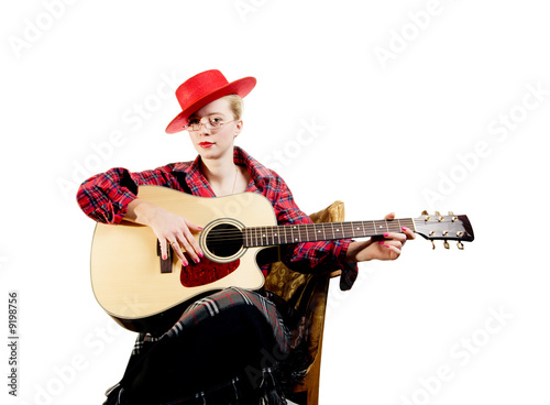 Aristocratic looking young woman playing on acoustic guitar.