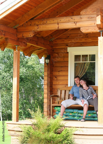 young couple drinking tea on verandah