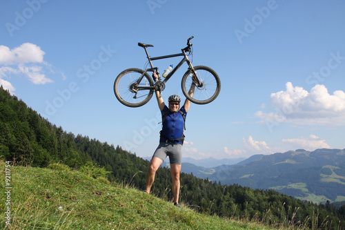 Mann mit Mountainbike am Gipfel