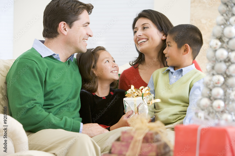 Family Smiling At Each Other,Holding Christmas Gift Family Smiling At Each Other,Holding Christmas Gift