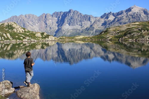 jeune garçon pêchant dans un lac de montagne